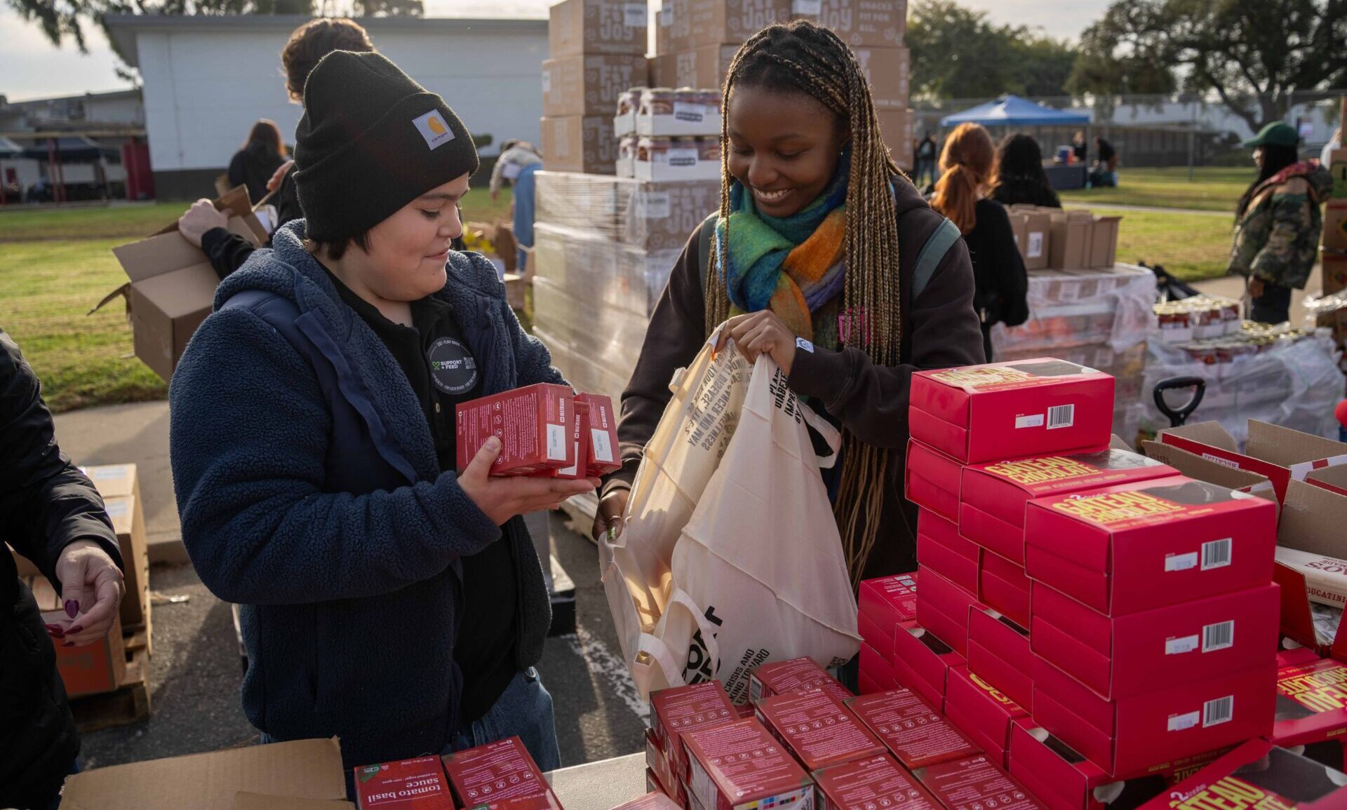 Volunteers loading boxes of produce at a Support+Feed distribution